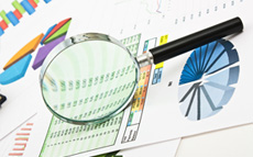 Photo of magnifying glass with business reports